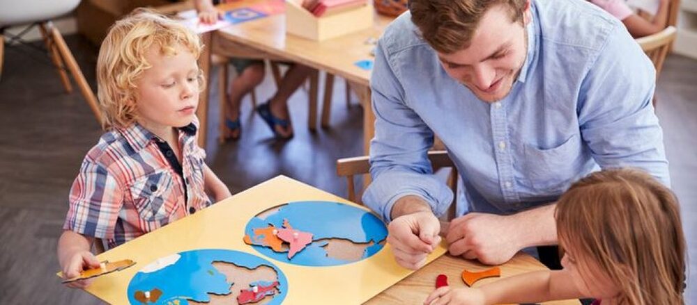 Teacher engaging with young students during a geography lesson with a world map puzzle.